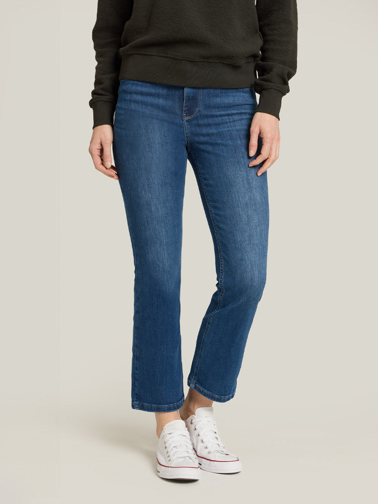 Women wearing Medium Blue High Rise Miniboot Ankle Logan Jeans